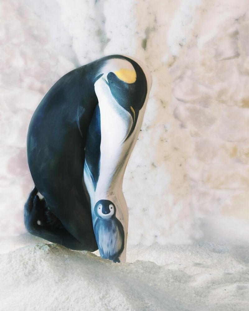 A penguin and their baby look perfectly at home on this person’s body